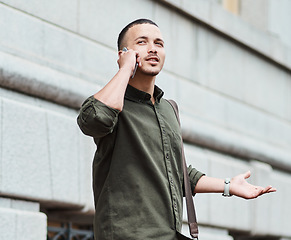 Image showing Lost man, traveler or tourist talking on a phone call asking for directions in a new city. A confused young male on vacation in an urban town looking around to find his hotel or the airport