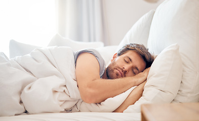 Image showing Home, bedroom and sleeping man in the morning lying his head on the pillow in apartment space. Tired, fatigue and relax male taking time off on the weekend in bed of airbnb or hotel accommodation