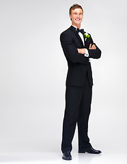 Image showing Wedding, marriage and groom with a handsome man standing arms crossed in studio against a white background. Happy male in a suit or tuxedo with a smile ready to get married at a celebration event