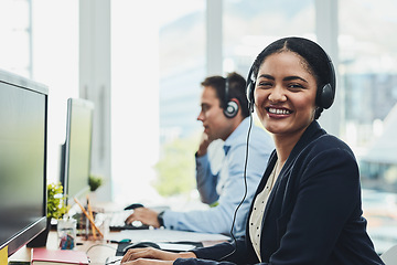 Image showing Portrait of happy call center agent working in a busy office, assisting clients and providing good customer service. Young, smiling and cheerful professional excited to offer support or help on calls