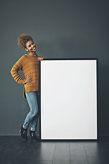 Image showing Young woman holding and showing an empty or blank sign for voicing an idea or advertisement announcement. Happy, excited and cheerful designer standing with mockup whiteboard or copyspace banner.