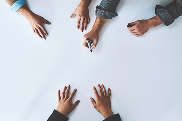 Image showing Business people writing on white paper in meeting, planning a marketing strategy and writing creative ideas together from above. Top view of hands of team of designers drawing a design on blank page