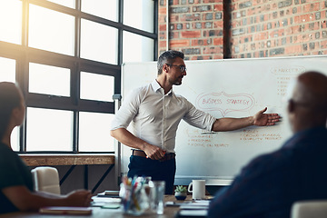 Image showing Take a look right here. Businessman doing a presentation in a meeting planning the company growth strategy in an office. Serious male entrepreneur briefing his team on the startup mission and vision.