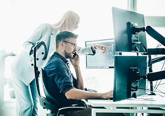 Image showing Stock broker business team trading online watching charts and data analyses on multiple computer screens in modern corporate work station office.