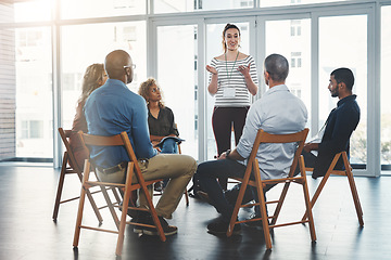 Image showing Group of diverse creative design business people, sitting in an innovation team growth meeting together. Modern casual employees listening to manager about support and unity in the workplace