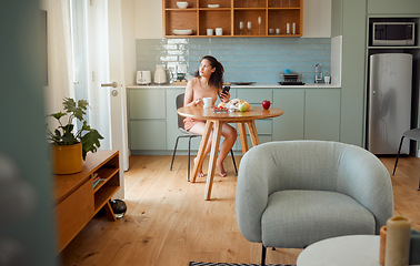 Image showing Woman on phone thinking of breakfast idea, healthy snack while drinking coffee in the morning in stylish kitchen. Relaxed and alone girl looking nostalgic in a modern apartment with interior design