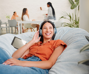 Image showing Listening to music, headphones and songs from a tablet playlist for creative relaxing, enjoying and lying on office bean bag. Smiling, happy and motivated business woman on break and feeling inspired