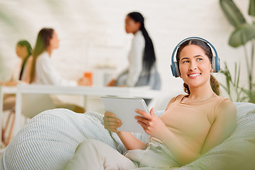 Image showing Thinking, idea and wondering female employee sitting and browsing on a tablet and headphones on a break in an office. Happy female marketing agency worker looking in the distance searching online
