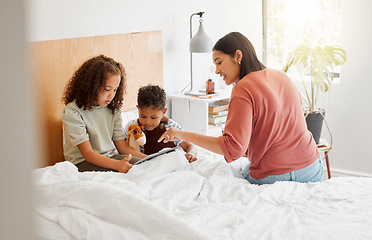 Image showing Mother and children learning on digital tablet online, family bonding with internet in bedroom and watching movies in bed at home. Boy and girl streaming videos, parent showing and teaching with tech