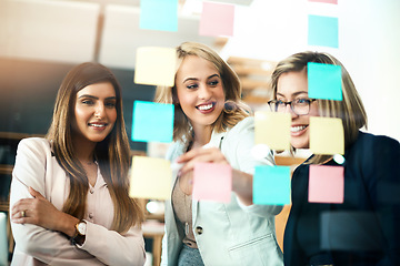 Image showing Female leader, team manager and boss planning with her colleagues on a glass wall using sticky notes. Strategy, mission and vision for a small business startup in the office boardroom for growth