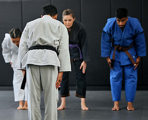 Image showing Fitness, strength and respect between karate trainer leading a class, bow and greeting martial arts student at a dojo or studio. Diverse group training and learning self defense and endurance skills