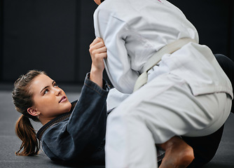 Image showing Strong, female and martial arts fighter training at an exercise studio with an opponent. Fit, young and active woman in a defense lesson at a dojo. Athlete lady practicing jujutsu with a partner.