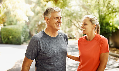 Image showing Happy mature couple keeping active, fit and healthy while jogging, running or going for walk outdoors in nature environment. Laughing senior man and woman enjoying a break from workout or exercising