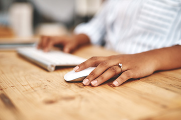 Image showing Hand on a mouse, clicking and scrolling while browsing online and surfing the internet. Closeup of a woman using a computer while sitting at a wooden desk. Connection with wireless technology.