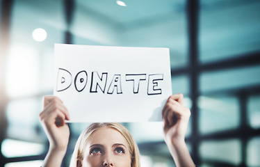 Image showing Donate, volunteer and give back to the community with a sign in the hands of a young woman inside. Closeup of a poster with text looking for welfare aid, donations and contributions to society