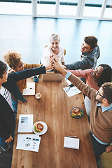 Image showing Diverse group of businesspeople high five after planning a meeting in an office. Above ambitious happy confident professional team of colleagues celebrating a success, achievement and feeling excited