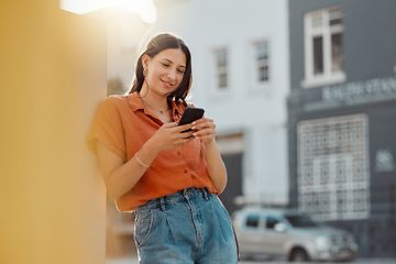 Image showing Texting on a phone, waiting for public transport and commuting in the city with a young female tourist enjoying travel and sightseeing. Looking online for places to see and visit while on holiday