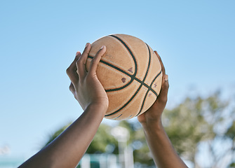 Image showing Basketball, sport and playing with a ball in the hands of a player, athlete or professional sportsperson. Closeup of a game or match outside on a court for health, recreation and fun in the sun