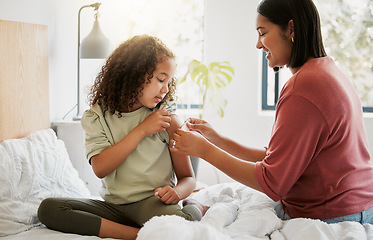 Image showing Loving mother comforting her daughter with a bandage in bed, being affectionate and caring at home. Young parent helping her sick child, applying a plaster and bonding, special moments of motherhood
