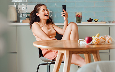 Image showing Woman browsing on phone reading social media post with an online app while relaxing in the kitchen. Female relaxing, smiling and enjoying a funny post, video or meme on the internet in the morning