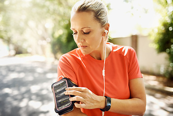 Image showing Mature, active and fit woman listening to music while running outside. Older person motivated for her positive, and athletic lifestyle. Female training for sport event or summer vacation body.