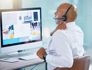 Image showing Stressed, back pain call center agent stretching bad, strained or sore muscle while working on computer. Behind of tired sales rep or support consultant working overtime or sitting long hours at desk