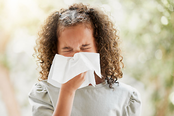 Image showing Sick little girl with a flu, blowing her nose and looking uncomfortable. Child suffering with sinus, allergies or covid symptoms and feeling unwell. Kid with a cold sneezing and holding a tissue