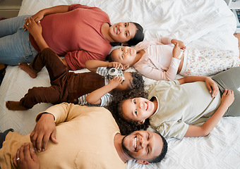 Image showing Fun family, children and parents bonding while lying on a bed in home bedroom from above. Portrait of playful, smiling and happy kids having fun with mother and father on weekend and making memories