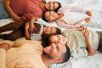 Image showing Happy mother, father and children together as a family lying, relaxing and bonding in the bedroom at home. Mom, dad and kids smiling, free and loving quality time together. Siblings with parents