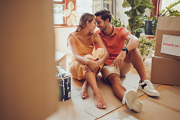 Image showing Romance, fun and an intimate moment between a couple moving into a new home. Young lovers being affectionate, flirting and enjoying a conversation. Husband and wife taking a break from unpacking