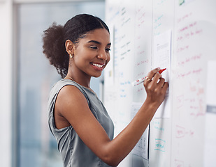 Image showing Female leader, manager or boss giving a presentation, seminar or workshop during a meeting in the boardroom. Young business woman writing on a whiteboard while teaching a class in a corporate office