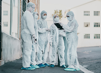 Image showing Covid, pandemic and healthcare team wearing protective ppe to prevent virus spread at a quarantine site. First responders wearing hazmat suits while discussing plan for cleaning and disinfecting