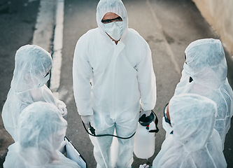 Image showing Covid pandemic outbreak team of doctors or medical workers wearing protective ppe to prevent spread of virus outside. Group of scientists wearing hazmat suit for corona or ebola disease in the street