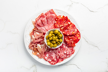 Image showing Assortment of Italian and Spanish sliced meat appetizer, prosciutto, salami and ham, with olives