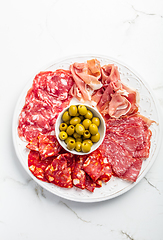 Image showing Assortment of Italian and Spanish sliced meat appetizer, prosciutto, salami and ham, with olives