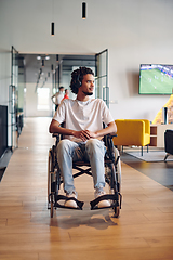 Image showing A businessman in a wheelchair occupies a hallway within a modern startup coworking center, embodying inclusivity and determination in the business environment