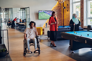 Image showing A businessman in a wheelchair occupies a hallway within a modern startup coworking center, embodying inclusivity and determination in the business environment