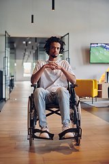 Image showing A businessman in a wheelchair occupies a hallway within a modern startup coworking center, embodying inclusivity and determination in the business environment