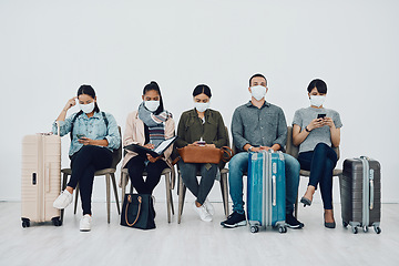 Image showing Travel and tourism during the pandemic with passengers wearing masks and being safe in an airport waiting line. Group of people in a departure lounge, ready to board and complying with covid protocol