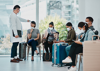 Image showing Covid doctor taking temperature of travel passengers in covid masks during tourism in an airport with an infrared thermometer. Medical professional following safe protocol in an epidemic or outbreak