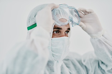 Image showing Covid, pandemic and healthcare worker wearing protective ppe to prevent virus spread at a quarantine site or hospital. Closeup of a doctor or scientist wearing a hazmat suit and goggles for safety