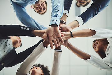 Image showing Team of business people hands stacked showing teamwork, collaboration and standing united for project development and innovation. Group of corporate colleagues joining in support and unity from below