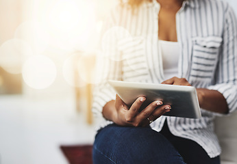 Image showing Tablet technology in the hands of a woman browsing social media, surfing the internet or chatting online with flare and copyspace. Closeup of a female sending an email message or reading news