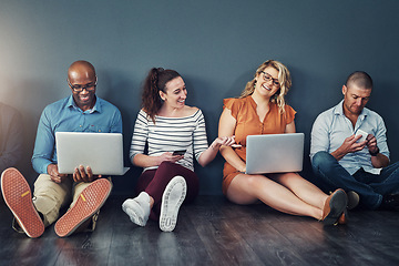 Image showing Diverse modern group of business people sitting on social media networking apps on their digital devices. creative team of work colleagues connected online with laptop pcs and phones