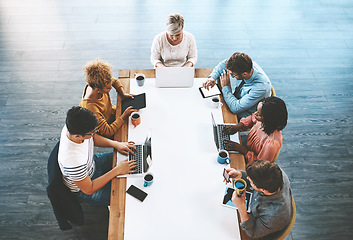 Image showing Colleagues planning, discussing strategy and searching online. Diverse business people talking in meeting, typing on laptops and browsing on tablet for ideas together in an office at work from above