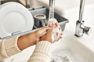 Image showing Hygiene, cleaning and washing hands with soap and water in the kitchen sink at home. Closeup of a female lathering and rinsing to disinfect, protect and prevent the spread of virus and germs