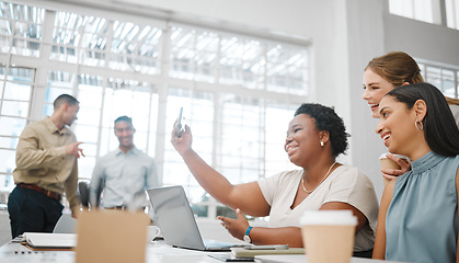 Image showing Diverse, creative and marketing team taking selfie in an office while working on a laptop together. Multiracial, happy and beautiful group of female friends having fun and celebrating at work.