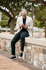 Image showing Stylish, cool smiling businessman on a phone in the park outside in nature. Happy man texting, chatting or reading social media messages on a smartphone outdoors on a break from work with copy space