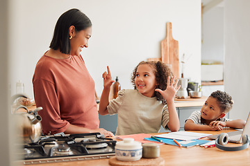 Image showing A mother smiling, teaching and helping children with homework in the kitchen. Mom and kids using the internet to homeschool her young daughter and son, to help with math, for a happy family and kids.