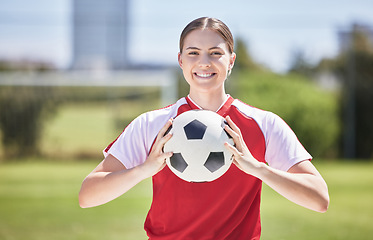 Image showing Soccer player, ball and young woman happy to play a fun sports game in a practice stadium field in summer. Exercise, training and workout of a healthy, fitness and athlete smiling on a grass pitch
